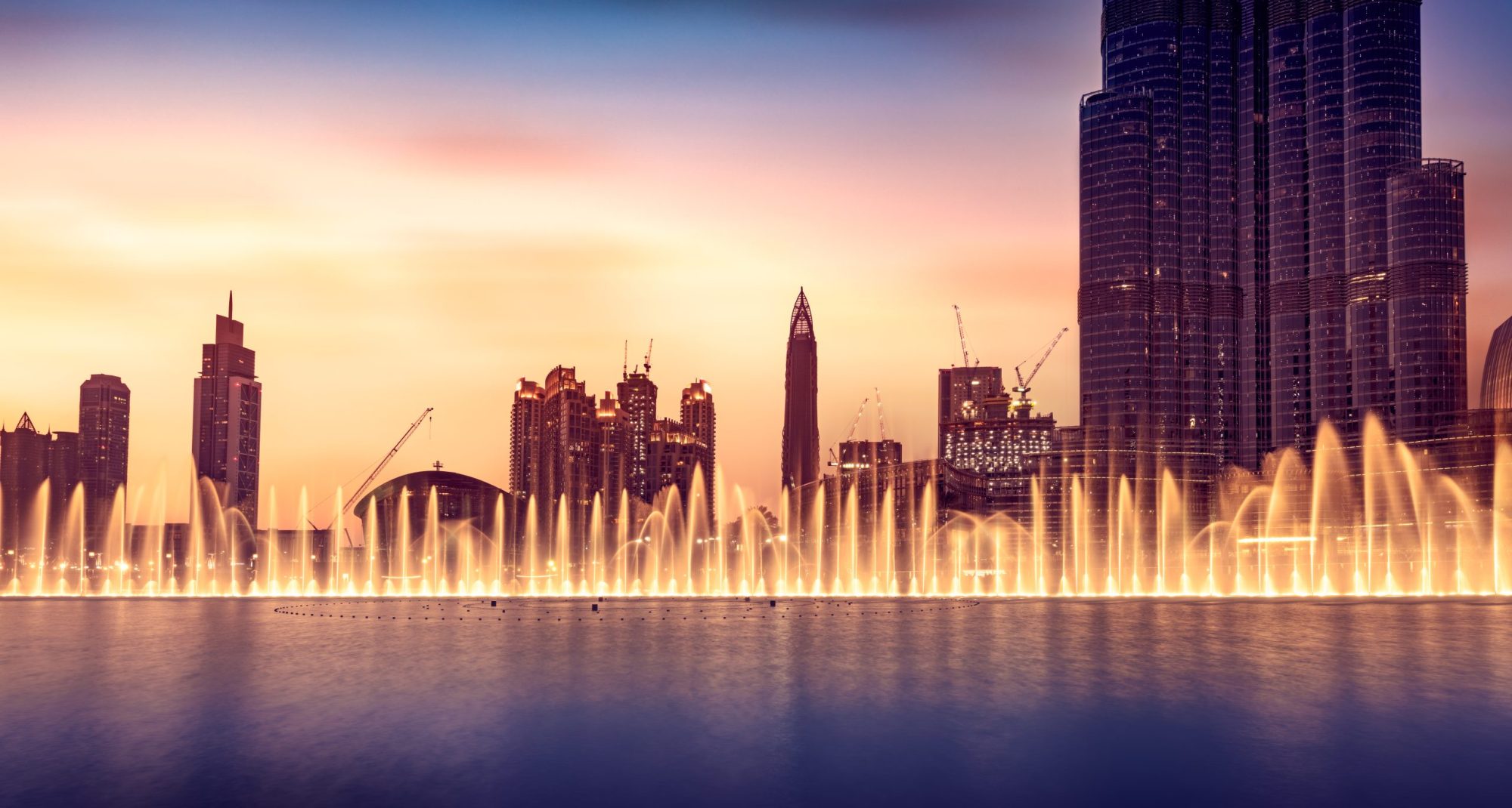 Musical fountain of Dubai, amazing beautiful fountain glowing at night, world famous tourist attraction, traveling to UAE